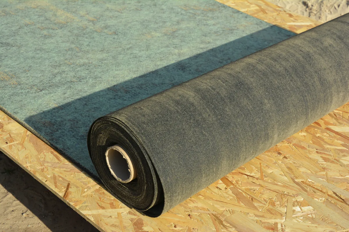 Roll of PP spunbond nonwoven roofing underlay on OSB board — construction membrane application
