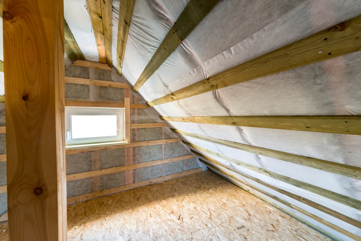 Interior timber frame with PP spunbond nonwoven house wrap installed on walls and roof structure