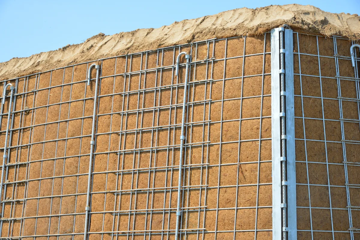Nonwoven geotextile erosion control fabric on retaining wall with steel mesh — civil construction application